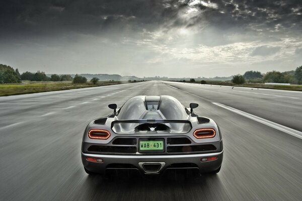 The sports car is driving fast on the highway