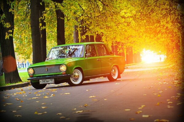 A small green car is parked in the park