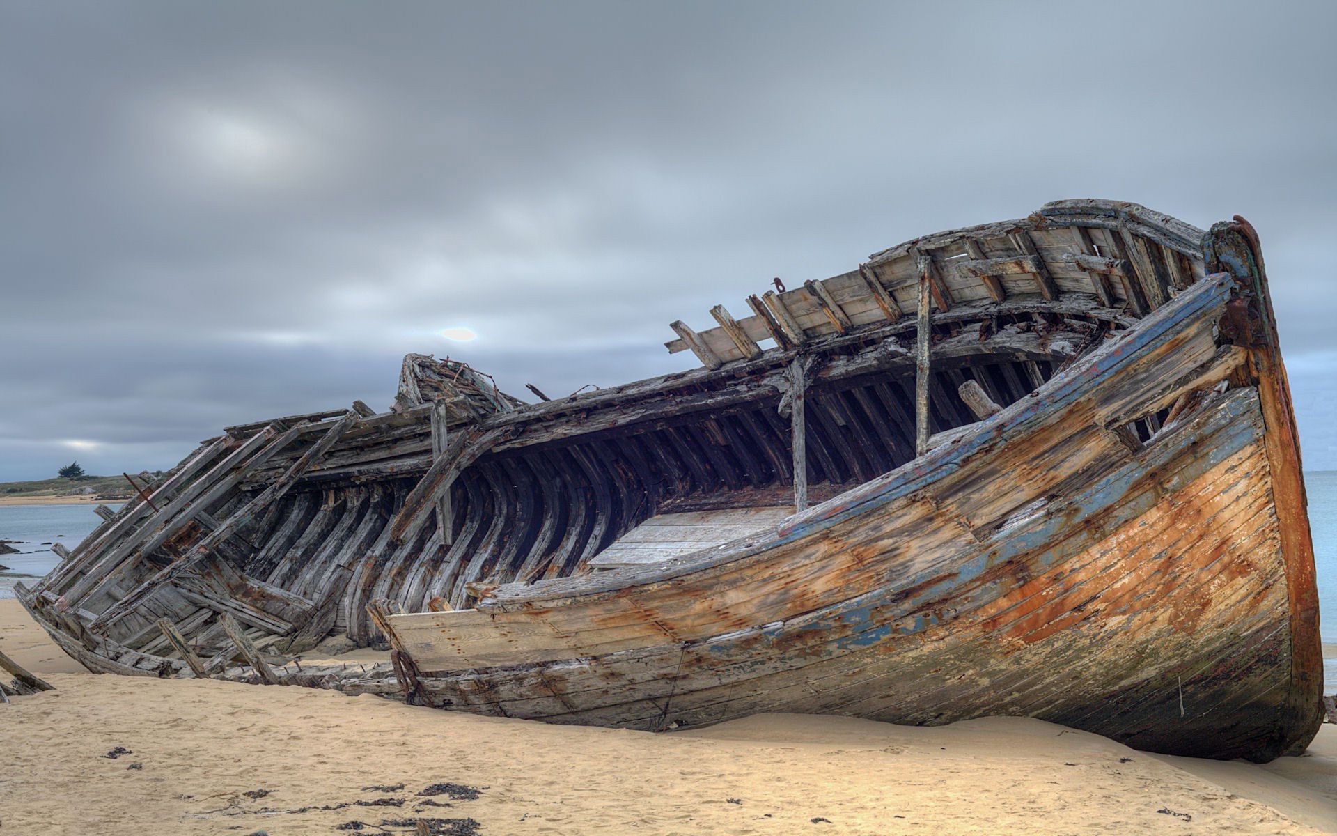 sea beach water ocean seashore travel sand boat sky nature vehicle landscape shipwreck abandoned outdoors watercraft